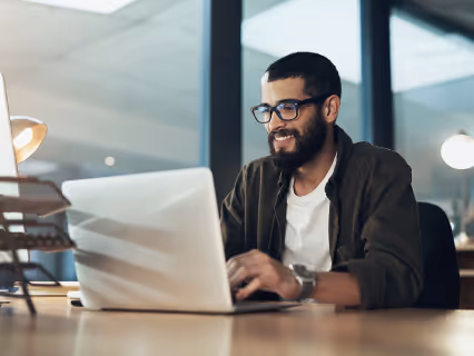 A smiling partner working on his laptop