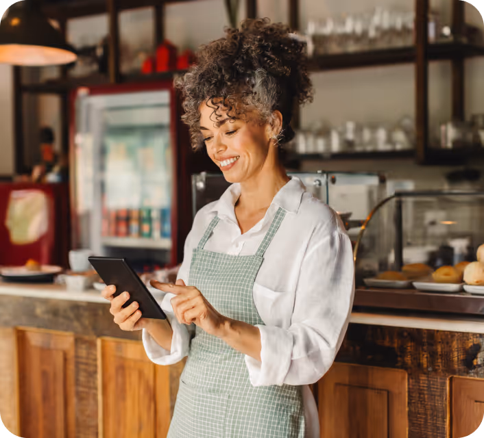 Shop owner on a tablet next to a Shopify checkout with the Local Delivery option selected